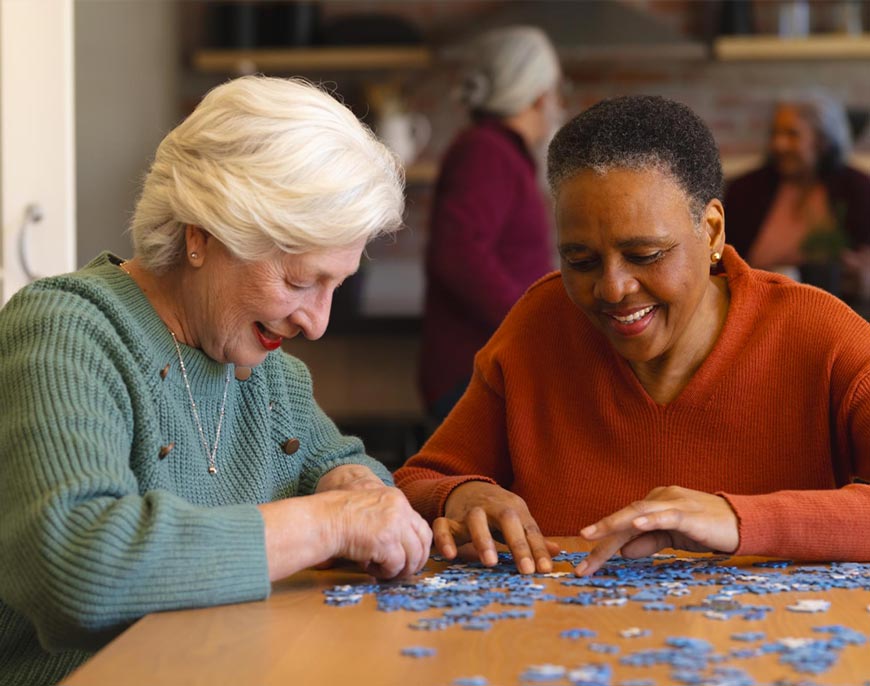 Smiling African seniors participating in a group activity at an adult day care centre with professional caregivers.